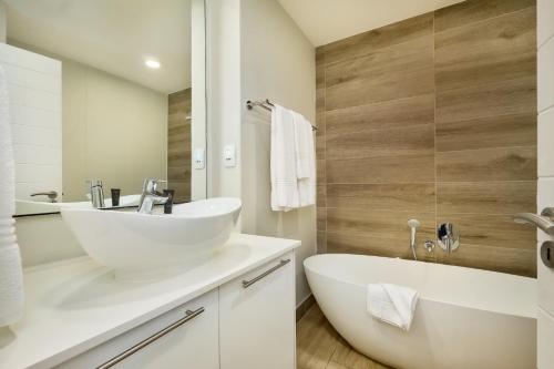 比勒陀利亚The Regency Apartment Hotel Menlyn的浴室配有白色水槽和浴缸。