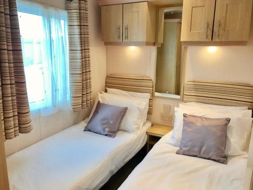 亨斯坦顿Heacham Golden Sunset Caravan Pets go Free的小型客房 - 带2张床和窗户