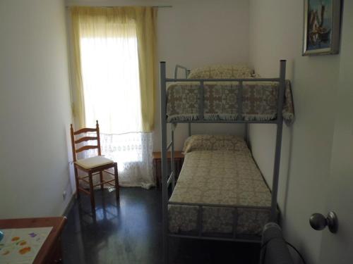 萨洛Zeus Alexis Frontal的一间卧室配有两张双层床和椅子