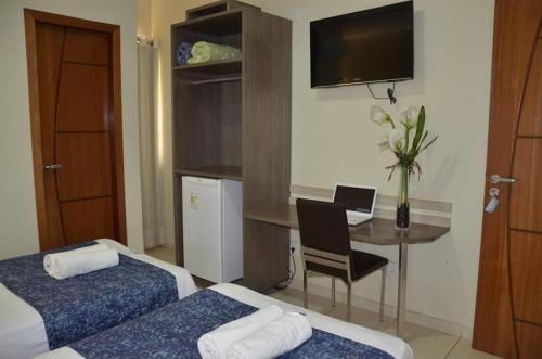 阿尔塔米拉帕雷斯酒店的酒店客房设有两张床和一张带笔记本电脑的桌子。