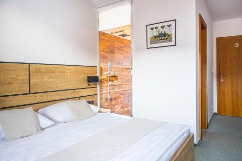 波普拉德达林卡旅馆的卧室配有白色的床和木制床头板