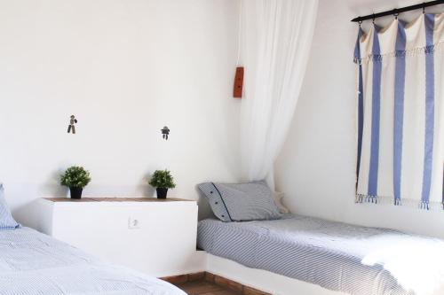 塔维拉Villa Pedras D'el Rei的一间卧室设有两张床和窗户。