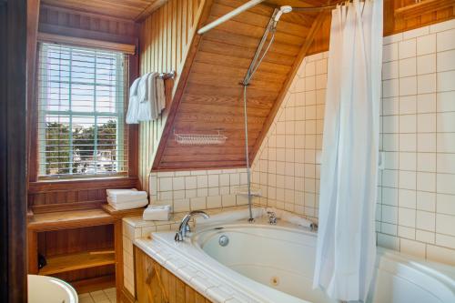 奥克拉科克The Castle B&B on Silver Lake的带浴缸、卫生间和窗户的浴室
