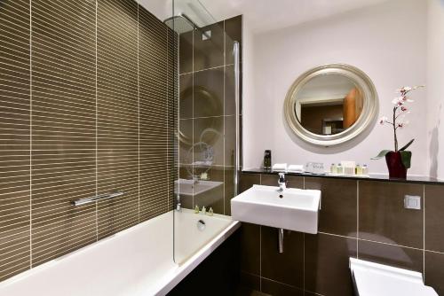 格拉斯哥格拉斯哥辉盛阁国际公寓的一间带水槽、浴缸和镜子的浴室