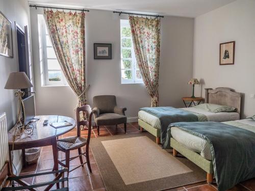 塞雷斯卡斯特Le Peyret的一间卧室配有两张床、一张桌子和一把椅子