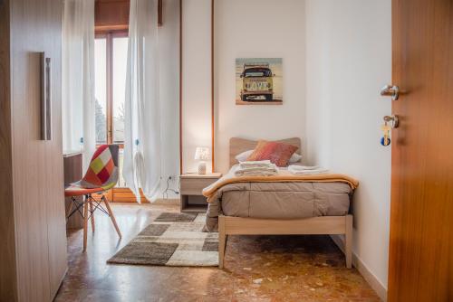 维罗纳Gabrielli Rooms & Apartments - MARONCELLI的卧室配有床、椅子和窗户。