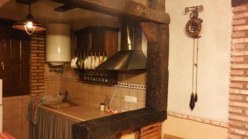 奥萨德蒙铁尔Casa Rural La Ossa的厨房配有水槽和炉灶 顶部烤箱