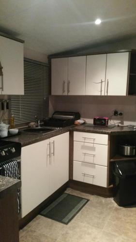 哈特尔普尔crimdon dene holiday park的厨房配有白色橱柜和水槽
