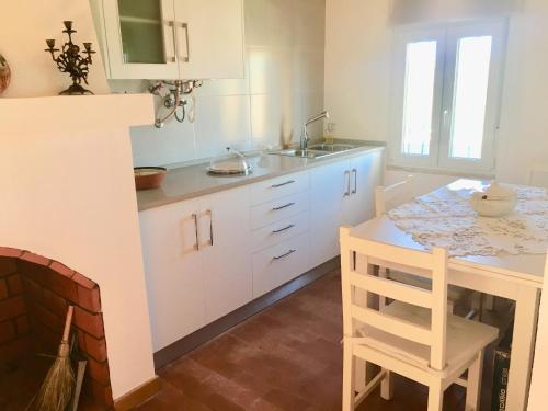 塞卡尔Casa do Chaparral campo e praia的厨房配有白色橱柜、桌子和水槽。