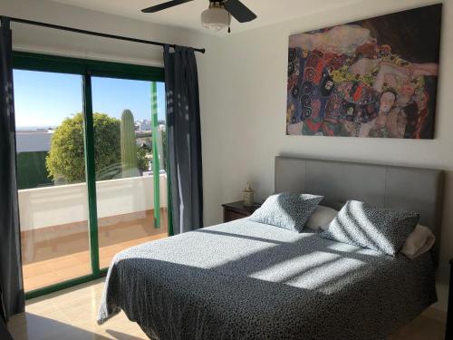 蒂亚斯Casa tranquila con vistas en la colina de tías的一间卧室设有一张床和一个大窗户