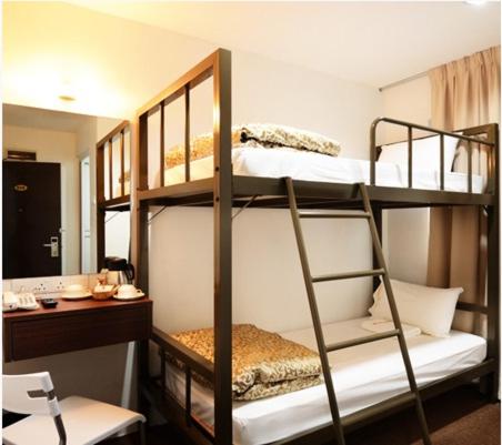 乔治市槟城路格兰德酒店的配有书桌的客房内的两张双层床