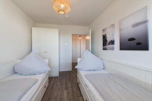 奥尔本尼兹Baltic Breeze的白色的客房设有两张床和吊灯。