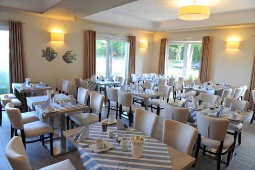 博尔滕哈根博尔滕哈格奥茨塞酒店的用餐室配有桌椅