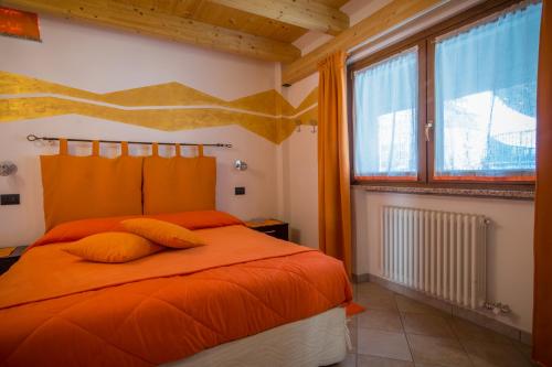 奥斯塔板球之家2号住宿加早餐旅馆的一间卧室配有橙色的床和窗户。