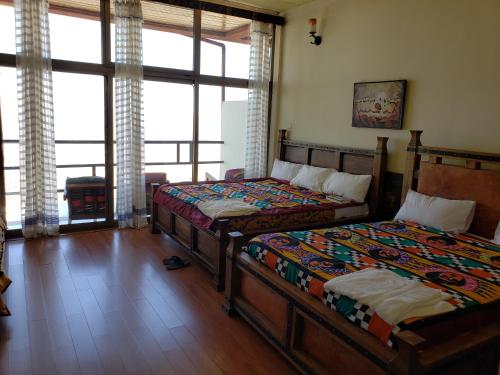 拉利贝拉Top Twelve Hotel - Lalibela的一间卧室设有两张床和大窗户