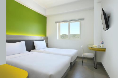 巴东巴东爱玛瑞斯酒店的绿墙客房的两张床