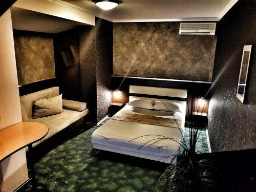 VladayaDiscret Hotel & Restaurant的一间卧室配有一张床和一张沙发