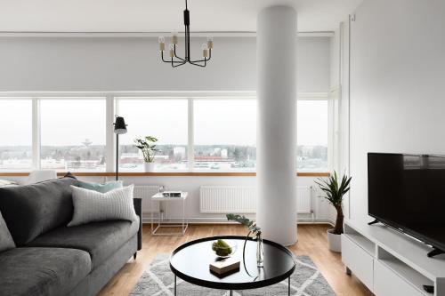 赫尔辛基SleepWell Apartments Itäkeskus, close to metro的客厅配有沙发和桌子