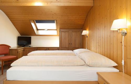 因特拉肯罗斯利假日公寓的一间带两张床铺的卧室,位于带木墙的房间内