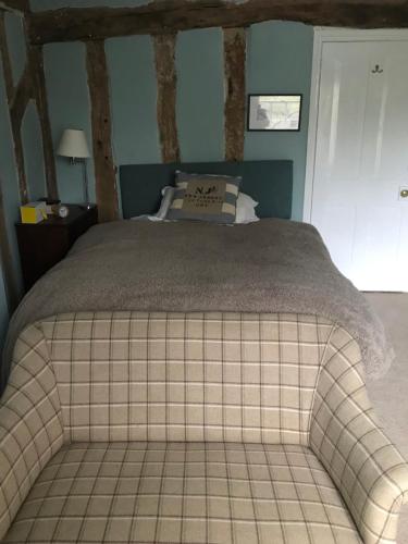 HartestWaldegrave farm的卧室设有一张大床,铺有瓷砖地板。