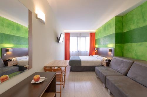 马德里Apartamentos Recoletos的酒店客房配有床、沙发和桌子。