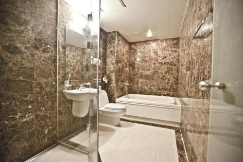首尔星驿酒店的浴室配有卫生间、盥洗盆和淋浴。