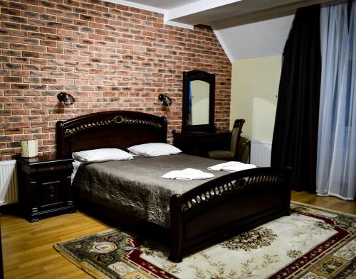 波利亚纳Recreation Complex Sunny Resort的一间卧室设有一张床和砖墙