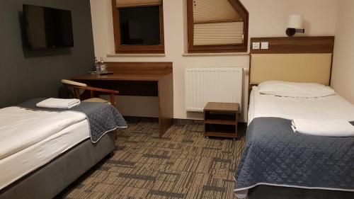 卢托维斯卡Centrum Promocji Leśnictwa w Mucznem的酒店客房配有两张床和一张书桌
