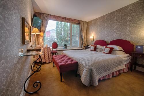 特拉凯圆桌俱乐部酒店的一间卧室设有一张大床和一个窗户。