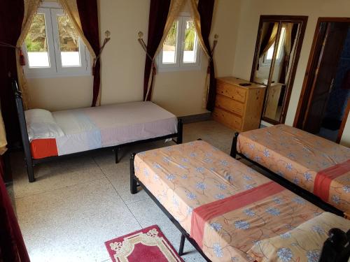 Tan-Tan PlageHotel Canarias Sahara的客房设有三张床、梳妆台和窗户。