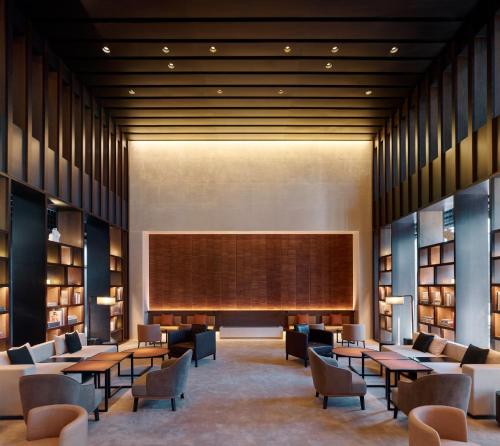 北京璞瑄酒店的一个带桌椅和大屏幕的图书馆