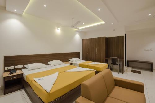 门格洛尔Hotel Karuna Residency的一间酒店客房,设有两张床和电视