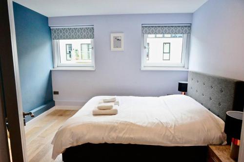 伦敦2BR/2Bath Luxury Modern Flat in the City London的一间卧室配有一张床,上面有两条毛巾