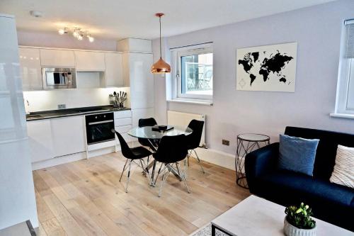 伦敦2BR/2Bath Luxury Modern Flat in the City London的厨房以及带桌椅的起居室。
