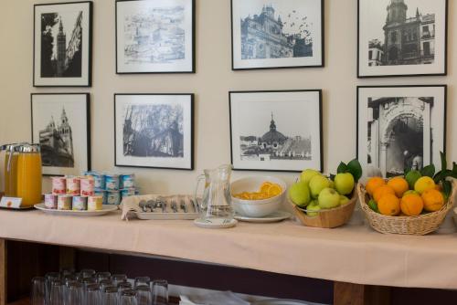 塞维利亚阿尔坎塔拉酒店的一张桌子,上面有水果,墙上有图片