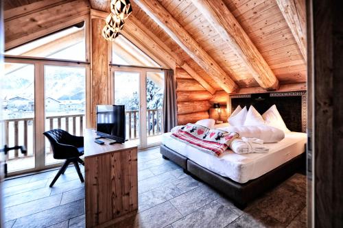普范德斯Summit Lodges的一间卧室配有一张床和一张书桌及电视
