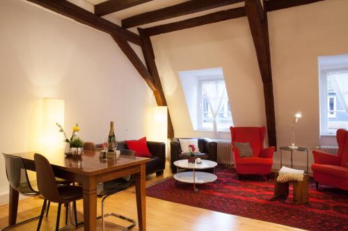 海德堡海德堡公寓的客厅配有桌子和红色椅子