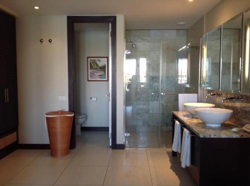 伊甸岛Eden Island luxury apartment sea view的一间带两个水槽和玻璃淋浴间的浴室