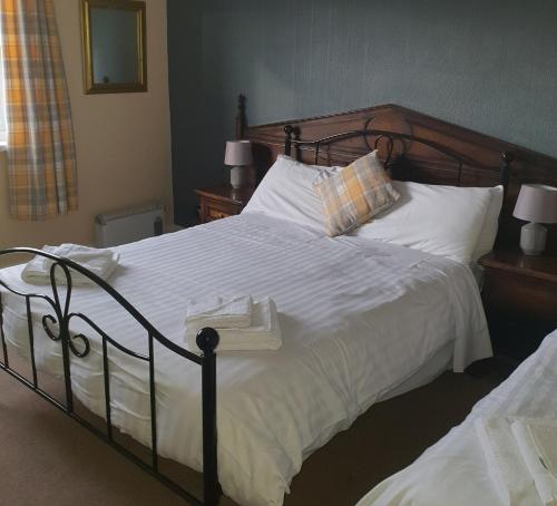 安南昆斯伯里阿姆斯酒店的卧室配有一张带白色床单和枕头的大床。