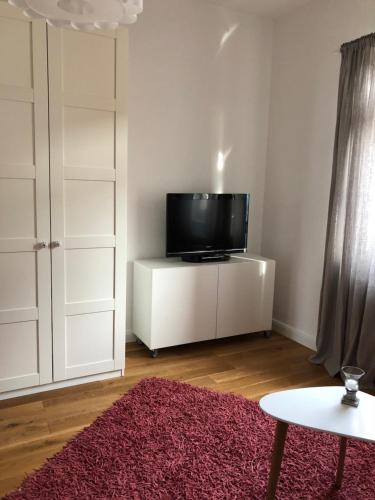 曼海姆Feel-Good Apartment In Mannheim-Neckarau的一间客厅,在白色的橱柜上配有电视