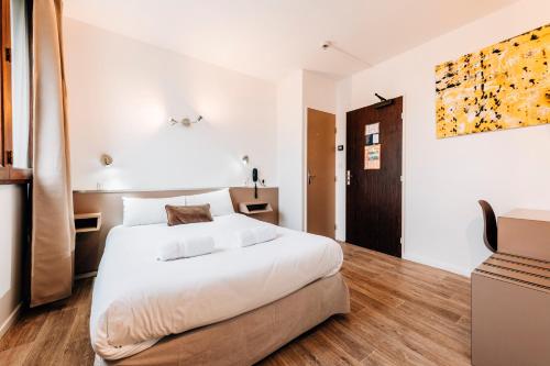 图卢兹爱丽兹酒店的卧室配有一张白色的大床,铺有木地板