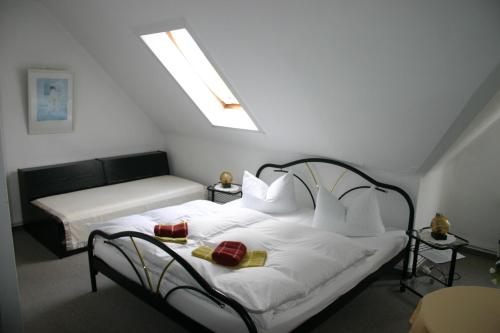 埃伦德博德塔尔酒店的一间卧室配有带白色床单和枕头的床。
