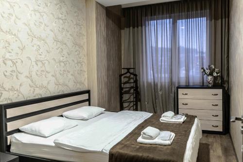 第比利斯TB Apart-Hotel in Tbilisi 1的一间卧室配有一张床、一个梳妆台和一扇窗户。
