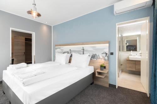 纽伦堡达斯保罗酒店的一间带白色大床的卧室和一间浴室