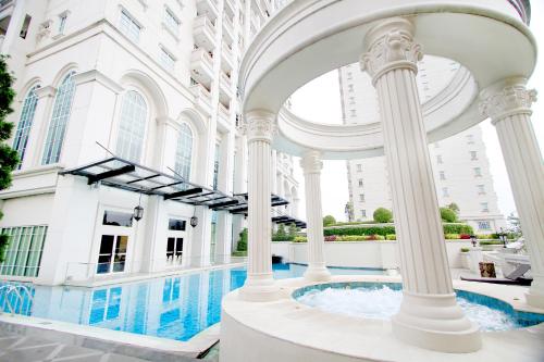 雅加达The Bellezza Hotel Suites的享有带游泳池和柱子的建筑景致