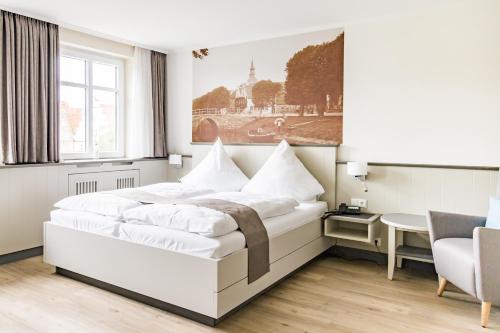 腓特烈Hotel Klein Amsterdam的白色卧室配有一张大床和一张桌子