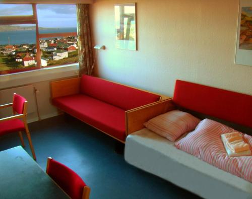 托尔斯港62N Guesthouse Marknagil的一间配有沙发、一张床和窗户的客房