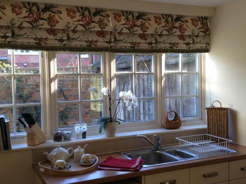BenendenFreshwater Barn的厨房设有三扇窗户、一个水槽和水槽