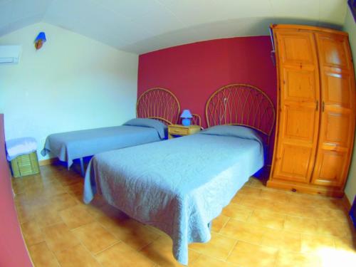 莱斯卡拉VACAY Villa Lin的一间卧室设有两张床和红色的墙壁