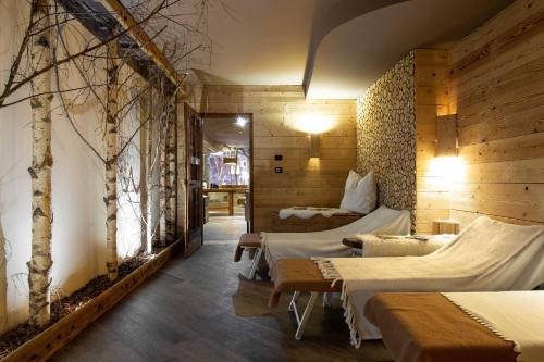 费拉迪普利米罗阿斯托里亚酒店的一间设有两张床的客房,墙上有树木
